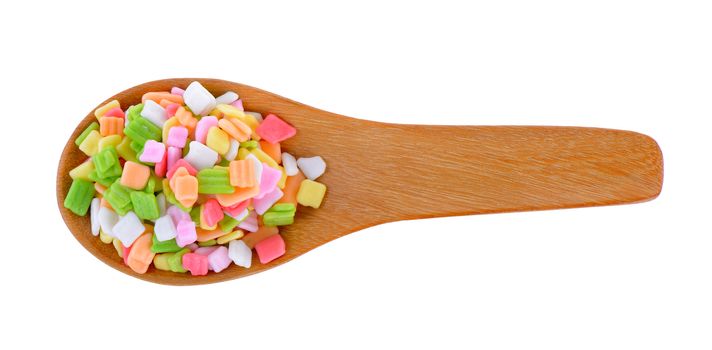 colorful candy in wood spoon on white background