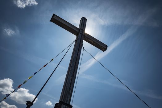 Summit cross Kampenwand with sun and blue sky