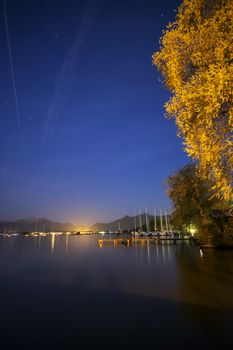Chiemsee at night with illuminated tree and stars