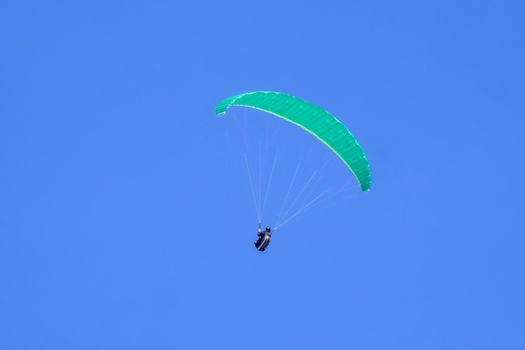 Paraglider in the blue sky at the Kampenwand in Bavaria, Germany