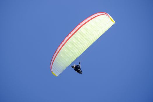 Paraglider in the blue sky at the Kampenwand in Bavaria, Germany