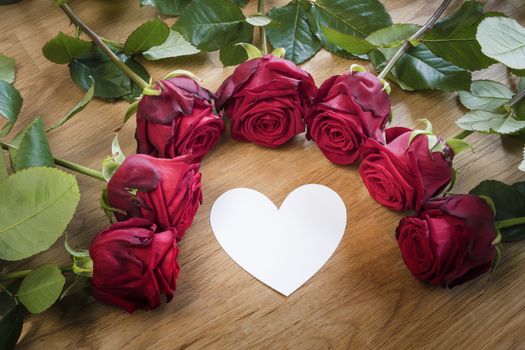 Red roses on a table with a white heart