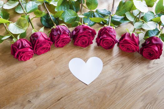 Red roses on a table with white heart