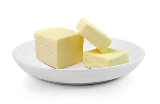 Stick of butter in plate on white background