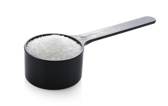 monosodium glutamate in spoon on white background