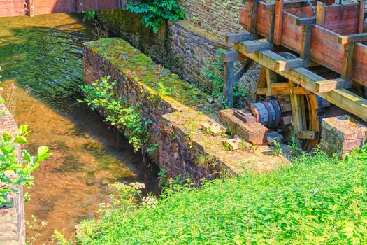 Historically watermill with a wooden wheel to drive a millstone.