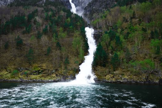 waterfall flows down among the mountains - Flam in Norway - fjords and the river