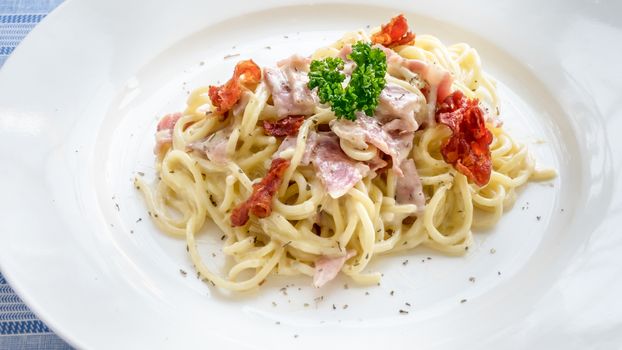 Spaghetti carbonara with bacon and cheese on white dish