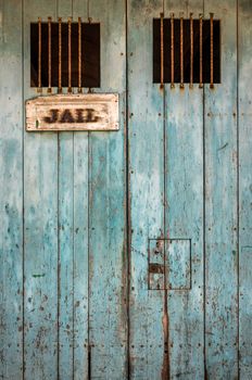 Detail Of A Rustic Jail Door With Bars On The Windows