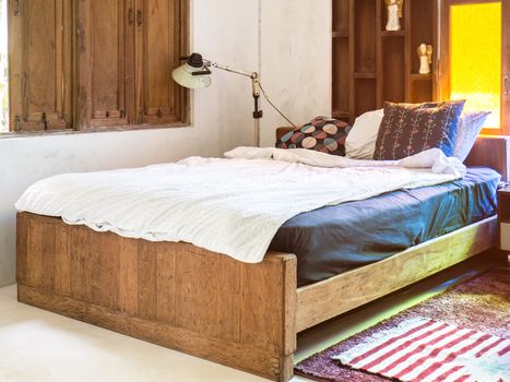 Vintage bedroom interior design with wooden bed and yellow glass window.