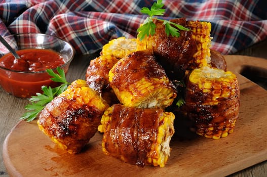 Grilled corn wrapped with bacon slices under BBQ sauce