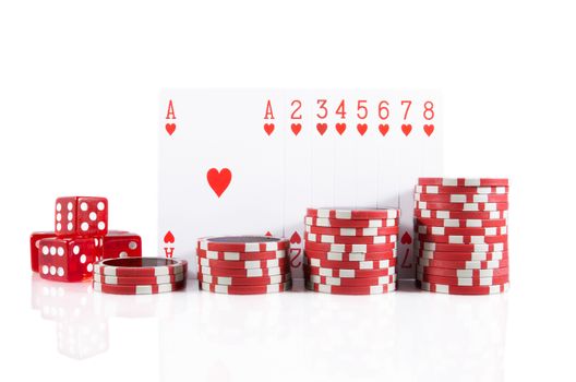 Group of poker cards, poker chips, and red dice over white isolated background