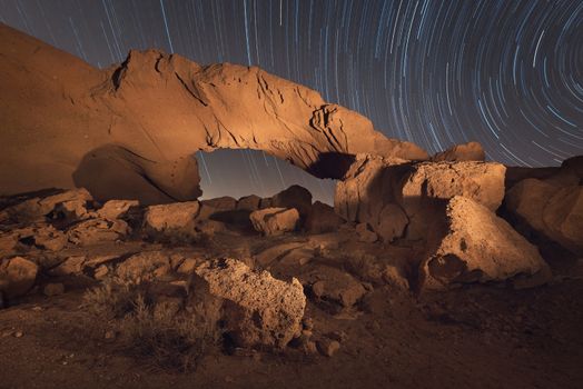 Star trails night landscape of a volcanic Rock arch in Tenerife, Canary island, Spain.