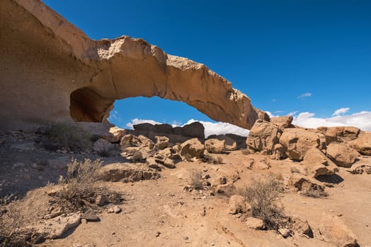 Natural volcanic rock arch formation in desertic landscape in Tenerife, Canary islands, Spain.