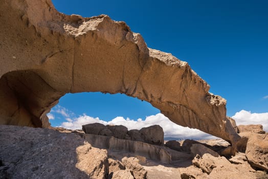 Natural volcanic rock arch formation in desertic landscape in Tenerife, Canary islands, Spain.