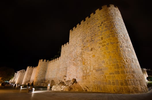 Night scene of famous Avila city walls in Castilla y Leon, Spain.