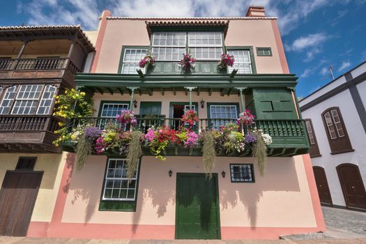 Famous ancient colorful colonies balconies decorated with flowers. Colonial houses facades in Santa Cruz, La Palma island in Spain