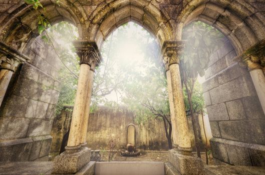 Ancient gothic arches in the myst. Fantasy landscape in Evora, Portugal.