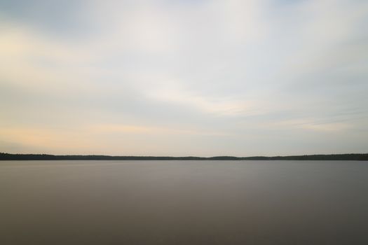 Lake with clouds and Calm Water and trees.