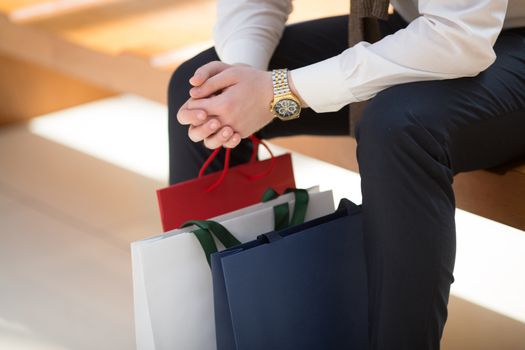 Sale and people - man with shopping bags sitting in shopping mall, close up