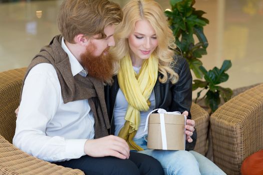 Happy beautiful young girl getting a gift from boyfriend