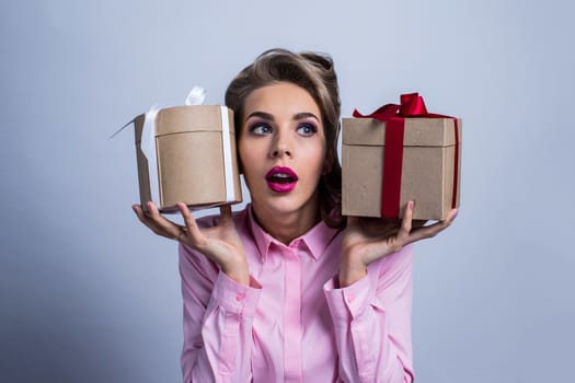 Young woman puts her ear to the presents with bows