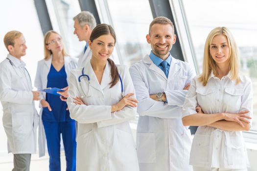 Medical team group portrait in hospital, people standing with arms crossed