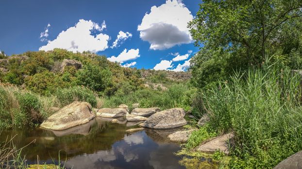 Panoramic view of deep granite Aktovo canyon with river and cloudy sky, One of the natural wonders of Ukraine.