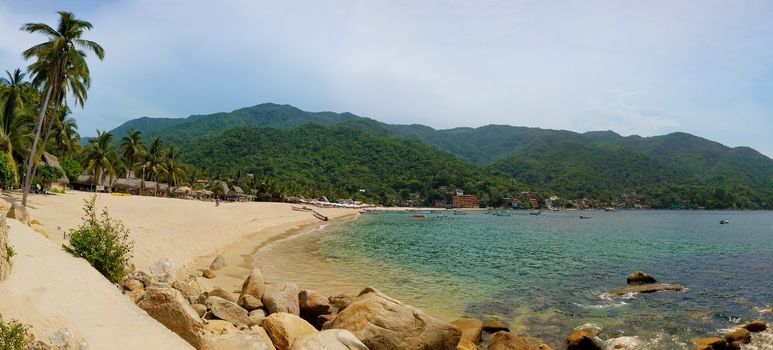 Panorama of Yelapa Beach on a sunny day, one of the most beautiful beaches near Puerto Vallarta, resort town in Mexico on the Pacific coast, in the state of Jalisco. The image was taken in July.