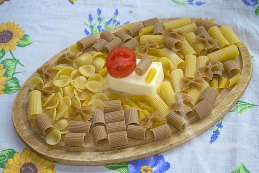  assorted wholemeal and normal raw pasta with butter and fresh tomato