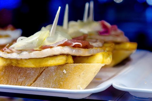 Montaditos typical of Spain with tenderloin cheese and onion also known as CHIVITO