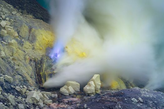 Blue sulfur flames and Sulfur fumes from the crater of Kawah Ijen Volcano in Indonesia.