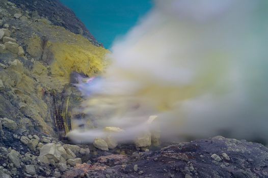 Blue sulfur flames and Sulfur fumes from the crater of Kawah Ijen Volcano in Indonesia.