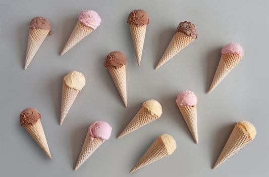 Many chocolate, vanilla and strawberry ice cream cones 