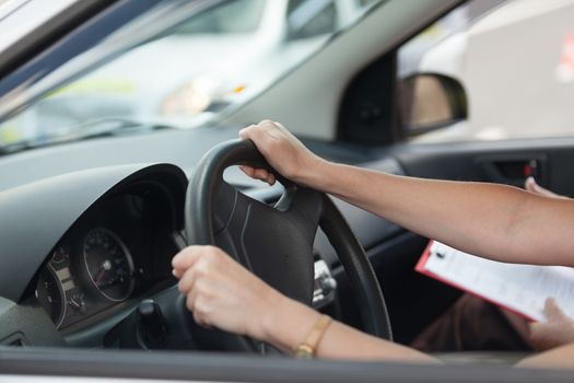 Learner driver student driving car with instructor