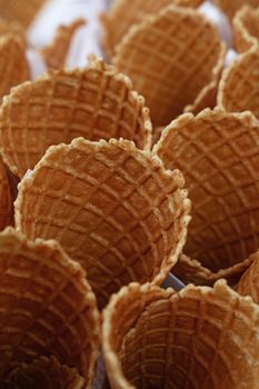 Several empty fresh wafer ice cream cone cornet cups with white paper napkins, close up, elevated high angle view