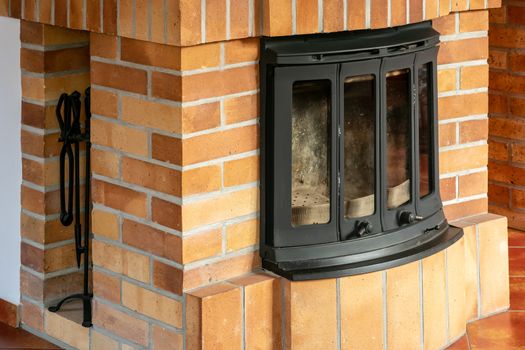 Fireplace, detail of home interior. Fireplace covered with fireclay bricks.