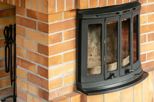 Fireplace, detail of home interior. Fireplace covered with fireclay bricks.