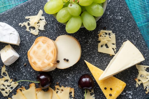 Cold appetizer. Cold cuts. Cheese on cutting board isolated on blue background, top view