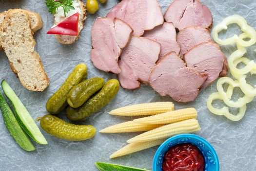 Cold appetizer. Cold cuts. Different snacks on a white crumpled paper, from above.