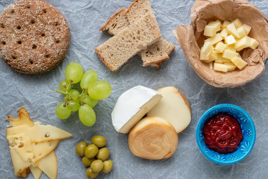 Cold appetizer. Cold cuts. Different snacks on a white crumpled paper, from above.