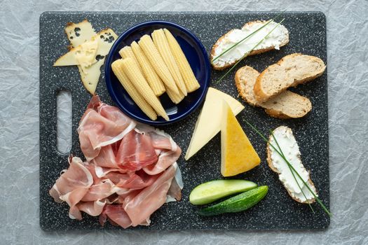 Cold appetizer. Cold cuts. Spicy food on black background, top view.