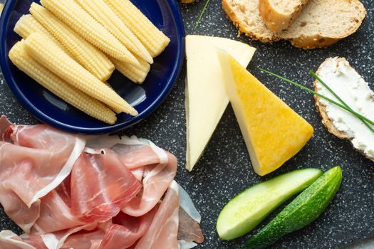 Cold appetizer. Cold cuts. Spicy food on black background, top view.