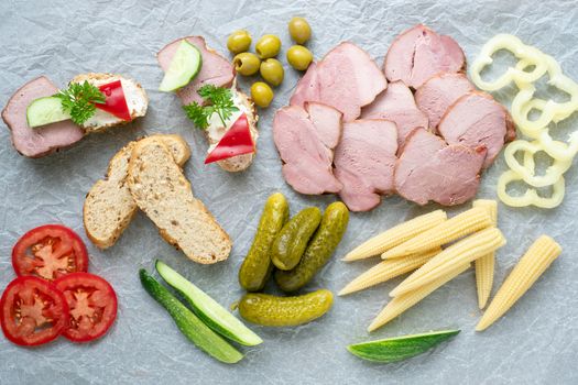 Cold appetizer. Cold cuts. Different snacks on a white crumpled paper, from above.