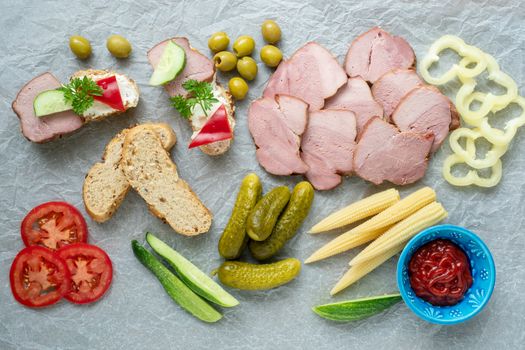 Cold appetizer. Cold cuts. Different snacks on a white crumpled paper, from above.