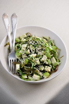 Salad from noodles from cucumbers and laminaria, slices of avocado with sesame