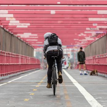 Man riding his bike in the cycling lane on Williamsburg Bridge, Brooklyn, New York City, USA.