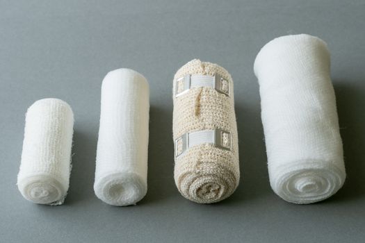 Different sizes of medical bandages. Medical bandages on grey background. Medical equipment.