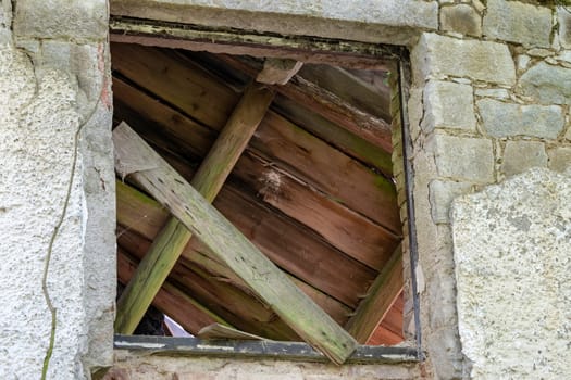 Wall with destroyed window. Broken window. Ruins brick house.