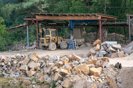 Mining in the granite quarry. Working mining machine - old digger. Mining industry.